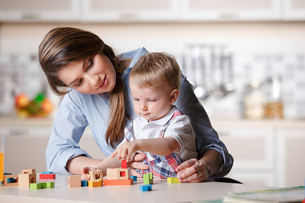 A smiling parent playing with blocks with their child